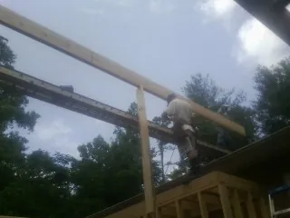 Carpenter setting a ridge beam over a new addition frame — Ice Dam Removal by Roofing Brothers in Jay