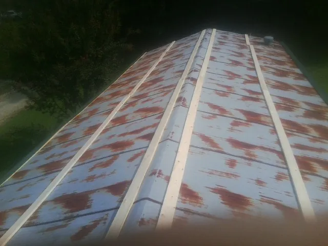 Rusted metal roof panels with new wood purlins before replacement — Storm Damage Roof Repair in Jay by Roofing Brothers