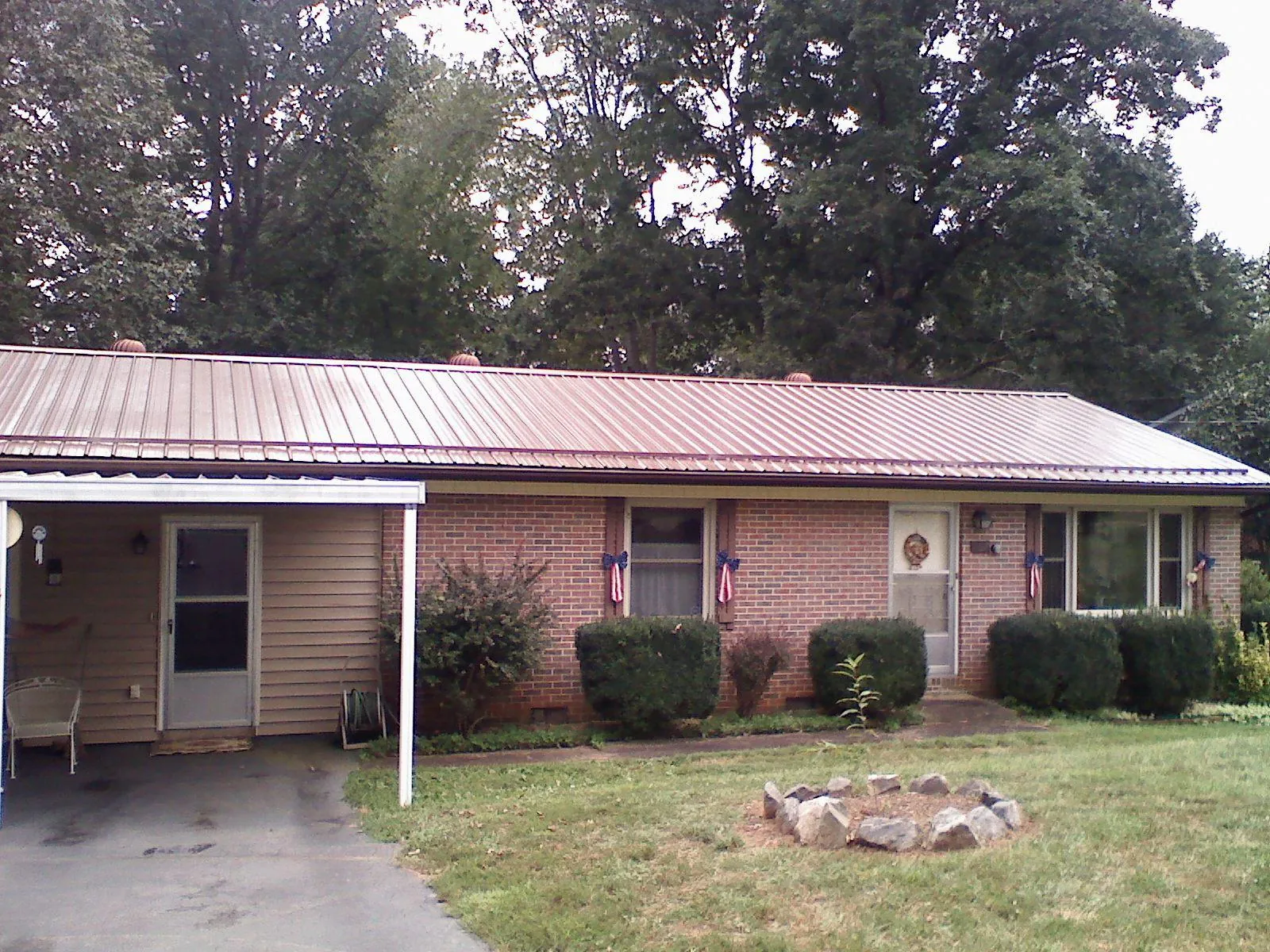 Bronze metal roof and carport on a brick ranch home — Roof Repair work by our crew in Jay